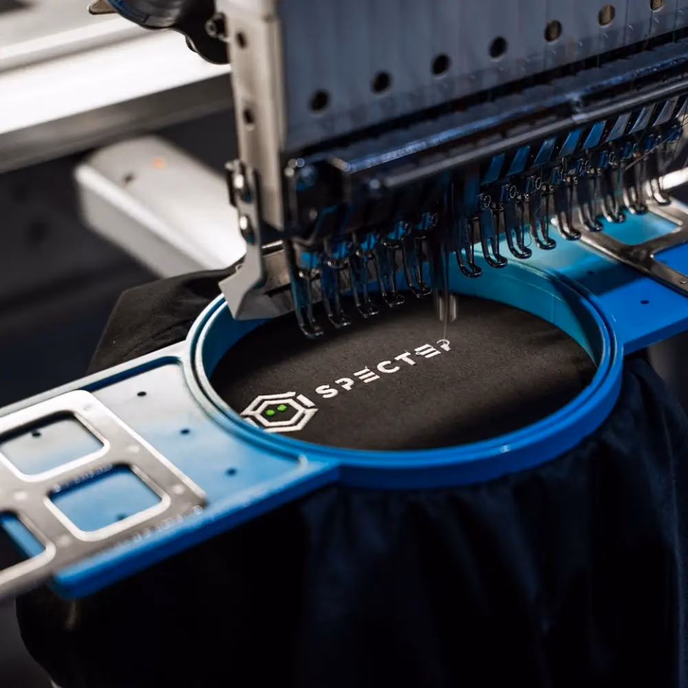 Embroidery machine stitching a branded polo